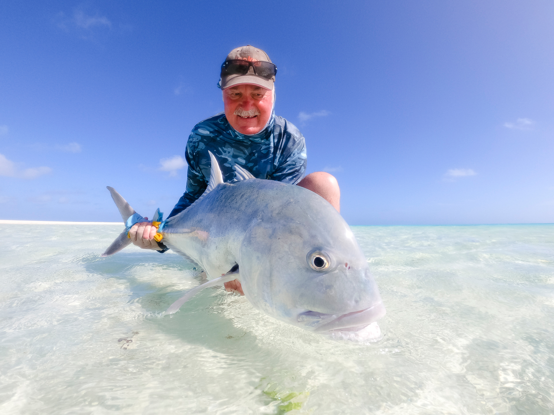 Two fishermen walking on a beach in Cape Verde island holding a